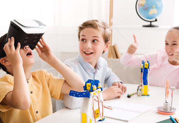 Happy school boy using VR glasses at technology lesson - Agrandir l'image, fenêtre modale