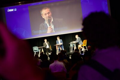 François GUYON, prend la parole lors d'une table ronde sur l'innovation, retransmis sur écran géant