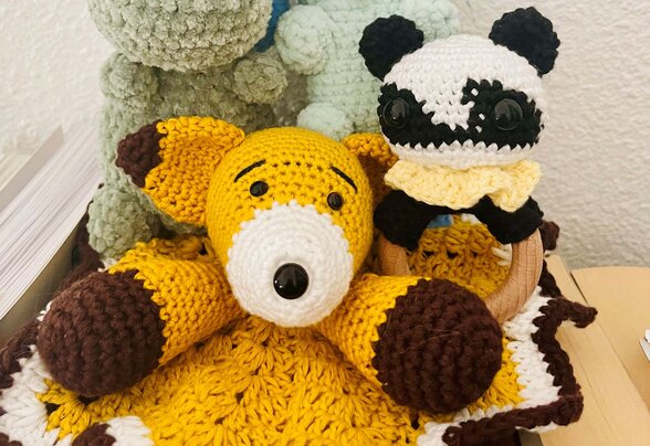 Plusieurs peluches amigurumi réalisées à la main : deux dinosaures, un renard doudou jaune et un panda noir et blanc. - Agrandir l'image, fenêtre modale