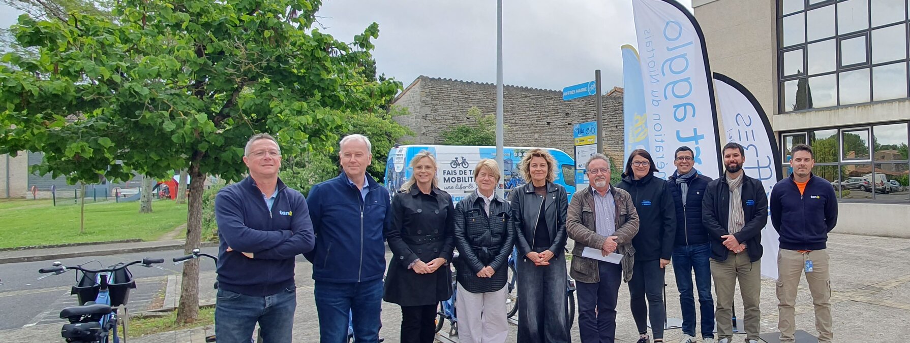 Groupe d'élus et partenaires de Niort Agglo réunis en extérieur pour l'inauguration d'une nouvelle station, un vélo VLS au premier plan.