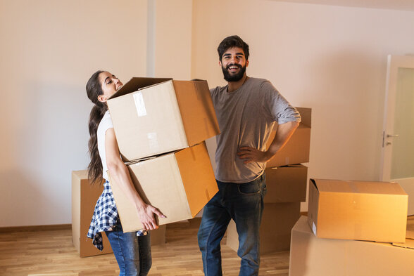 Deux jeunes gens transportant des cartons dans un logement lors d'un déménagement - Agrandir l'image, fenêtre modale