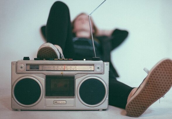 Personne allongée au sol écoutant de la musique sur une radio cassette vintage - Agrandir l'image, fenêtre modale