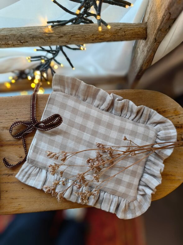 Réalisation cousue en tissu vichy beige à carreaux, bordure à fronces et ruban brun noué, posée sur une étagère en bois - Agrandir l'image, fenêtre modale
