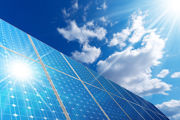 Rangées de panneaux photovoltaïques orientés vers le soleil sous un ciel bleu nuageux - Agrandir l'image, fenêtre modale
