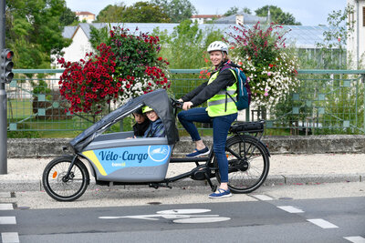 Velo cargo en circulation dans la ville Noemie Wemaere loueuse d?un mois. Vélo cargo en circulation dans la ville Noémie Wemaere loueuse d'un mois.