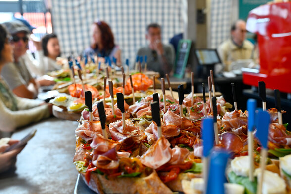 Assortiment de tapas garnis de jambon, légumes et œuf, présentés sur le comptoir d'un stand des Halles de Niort - Agrandir l'image, fenêtre modale