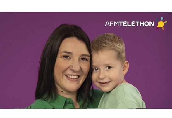Visuel officiel AFM-Téléthon avec une femme et un jeune enfant souriants sur fond violet - Agrandir l'image, fenêtre modale