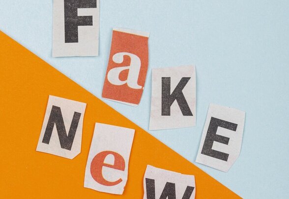 Lettres découpées dans des journaux épelant « Fake News » sur fond bicolore bleu et orange - Agrandir l'image, fenêtre modale