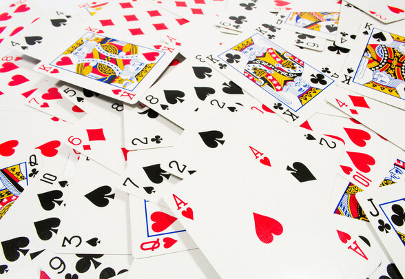 Cartes à jouer éparpillées sur une table blanche, mêlant as, rois, valets et figures colorées - Agrandir l'image, fenêtre modale