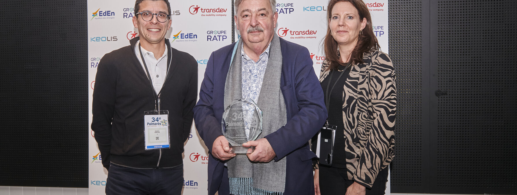 Trois représentants de Niort Agglo et Transdev tenant le trophée du 34e Palmarès VRT Territoires & Mobilités.