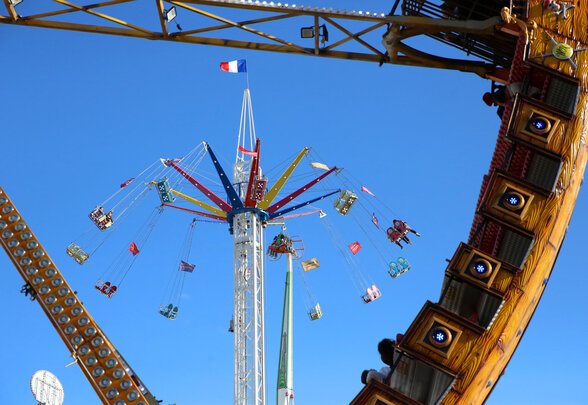 Grande tour de chaises volantes multicolores avec passagers suspendus dans les airs, drapeau tricolore au sommet - Agrandir l'image, fenêtre modale