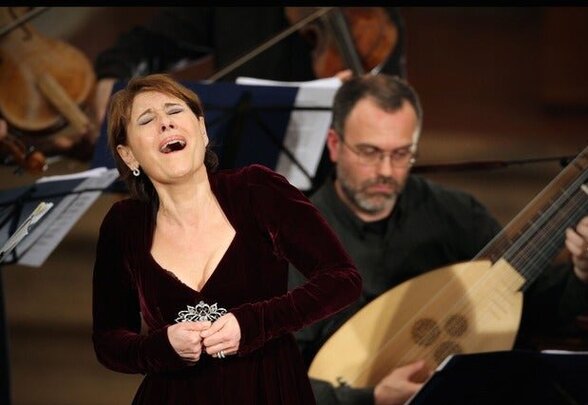 Soliste lyrique interprétant un morceau lors d'un concert avec musiciens et instruments à cordes en arrière-plan - Agrandir l'image, fenêtre modale