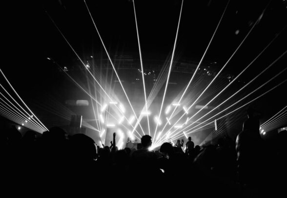 Foule en silhouette devant une scène illuminée de faisceaux laser lors d'un concert - Agrandir l'image, fenêtre modale