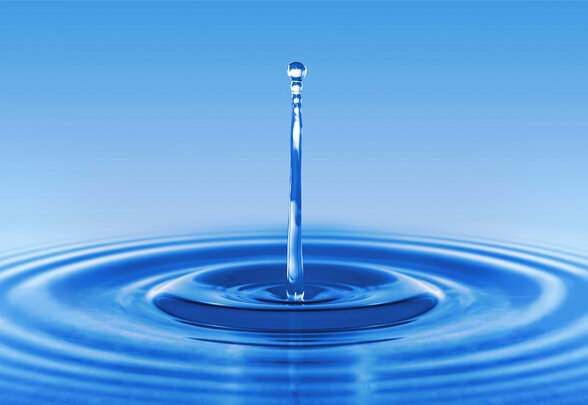 Goutte d'eau en suspension créant un jet et des ondulations concentriques à la surface d'une eau bleue - Agrandir l'image, fenêtre modale