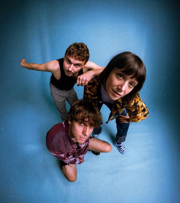 Le groupe DITTER en pose dynamique photographié en vue plongeante sur fond bleu, les membres regardant l'objectif - Agrandir l'image, fenêtre modale