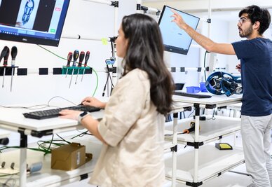 Deux étudiants travaillent sur ordinateurs et équipements techniques dans un atelier pédagogique de l'ENSAM Niort.