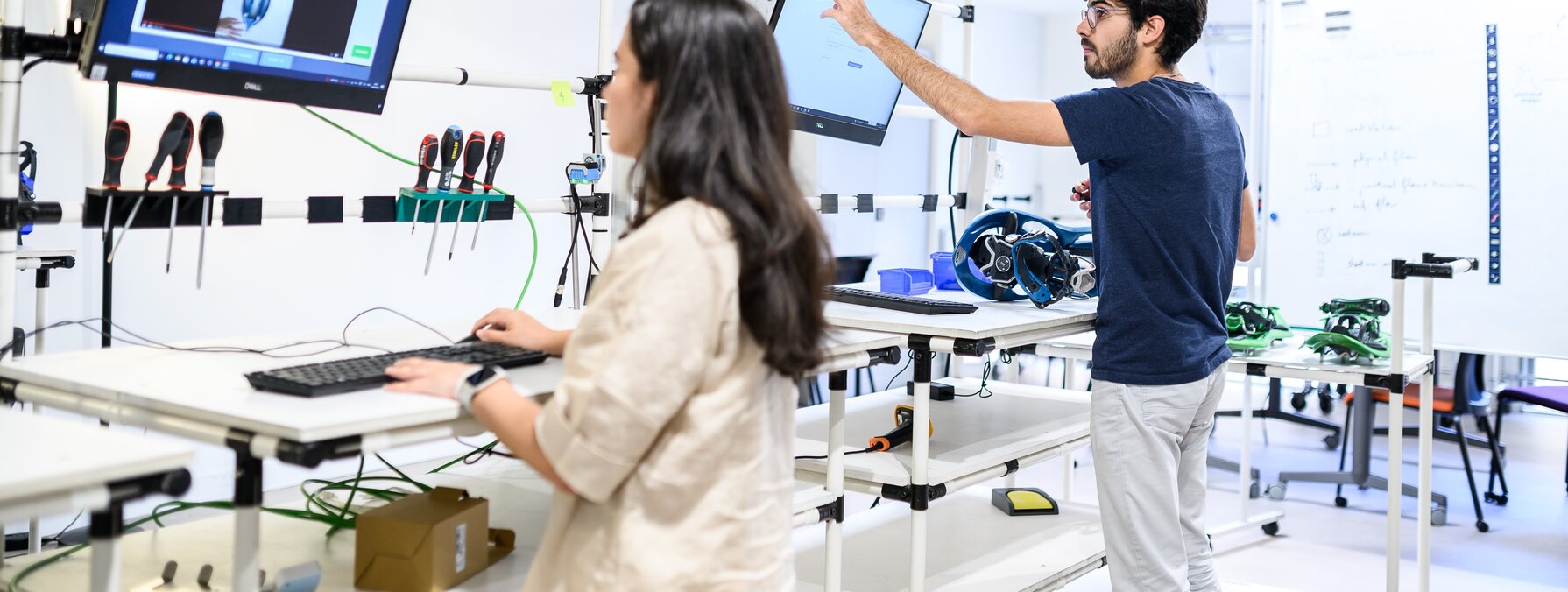 Deux étudiants travaillent sur ordinateurs et équipements techniques dans un atelier pédagogique de l'ENSAM Niort.