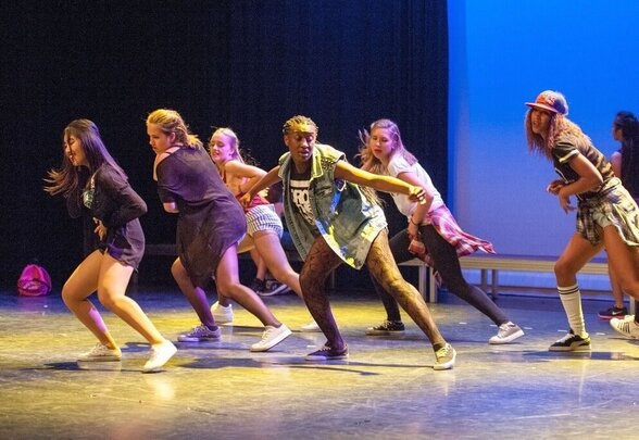 Groupe de danseurs hip-hop en pleine performance sur scène, éclairés par des lumières bleues et dorées - Agrandir l'image, fenêtre modale