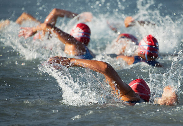 Nageurs en eau libre portant des bonnets rouges lors de l'épreuve de natation en compétition de triathlon - Agrandir l'image, fenêtre modale