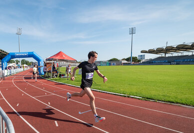 Coureur en compétition sur la piste d'athlétisme du stade