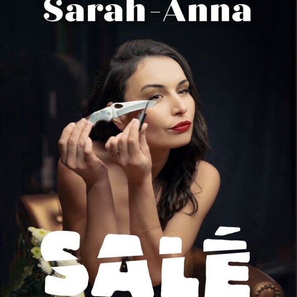 Affiche du spectacle SALÉ de Sarah-Anna : l'humoriste tient un couteau près de l'œil en pose décalée - Agrandir l'image, fenêtre modale