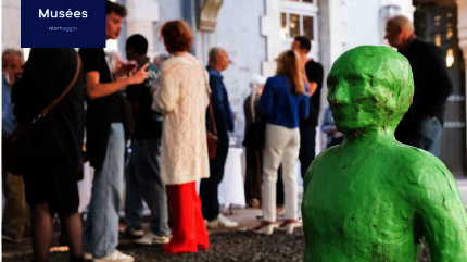 Sculpture verte au premier plan, participants en discussion en extérieur lors d'un événement au musée - Agrandir l'image, fenêtre modale