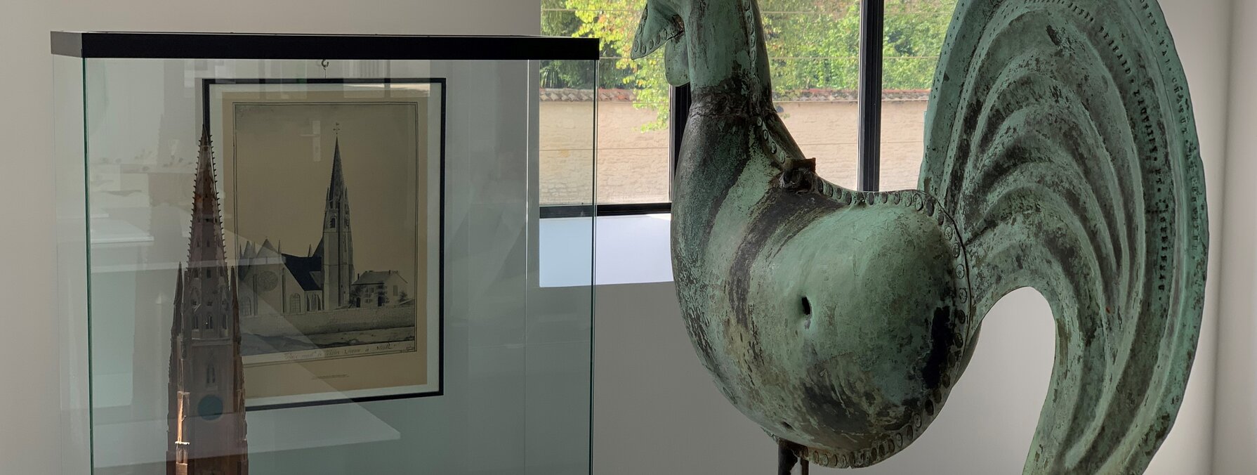 Coq en métal à patine verte monté sur socle, accompagné d'une maquette et d'une gravure de Notre-Dame de Niort