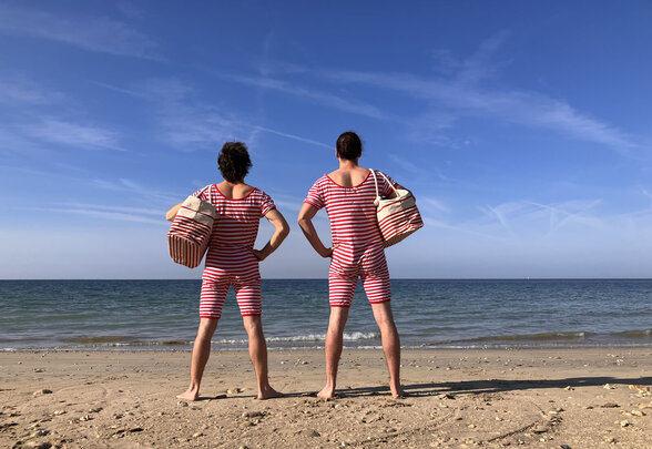 Deux artistes de dos en maillots rayés rouge et blanc sur une plage, face à la mer - Agrandir l'image, fenêtre modale