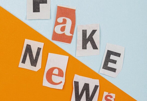 Mots 'Fake News' composés de lettres découpées dans des journaux collées sur un fond bicolore bleu et orange - Agrandir l'image, fenêtre modale