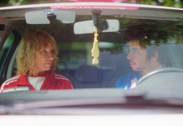 Sprite et Marie-Charlotte face à face dans une voiture d'auto-école aux couleurs roses, scène du film - Agrandir l'image, fenêtre modale