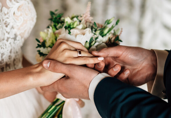 Échange d'alliances entre deux mariés, bouquet de fleurs blanches tenu par la mariée en robe de dentelle - Agrandir l'image, fenêtre modale