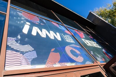 Devanture vitrée du bâtiment d'accueil avec les grandes affiches graphiques INNN 2025 à Chauray Niort