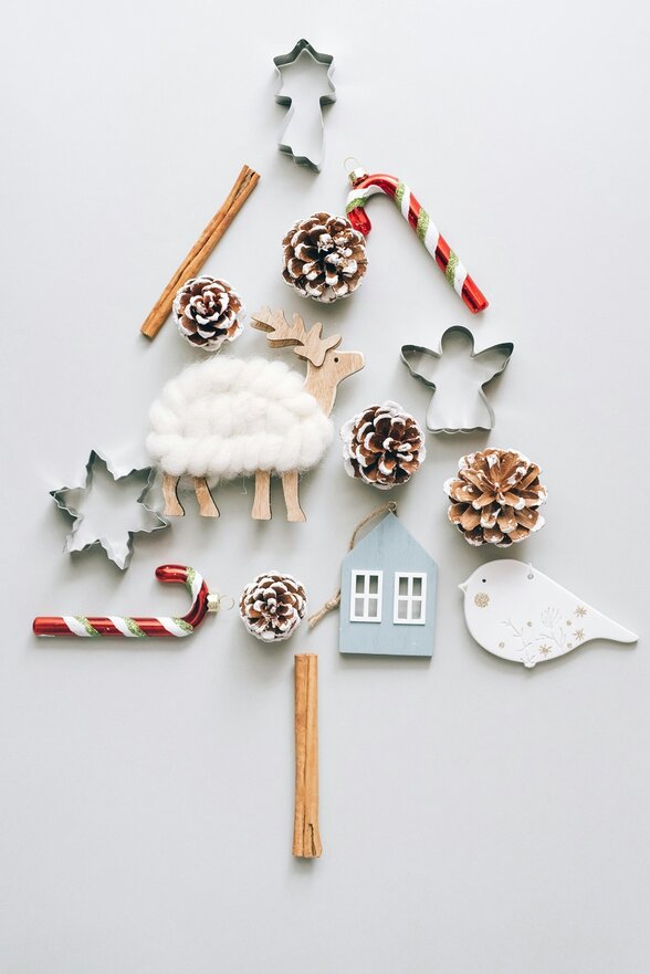 Décorations de Noël artisanales disposées en forme de sapin : pommes de pin, emporte-pièces, figurines en bois et bâtons de cannelle - Agrandir l'image, fenêtre modale