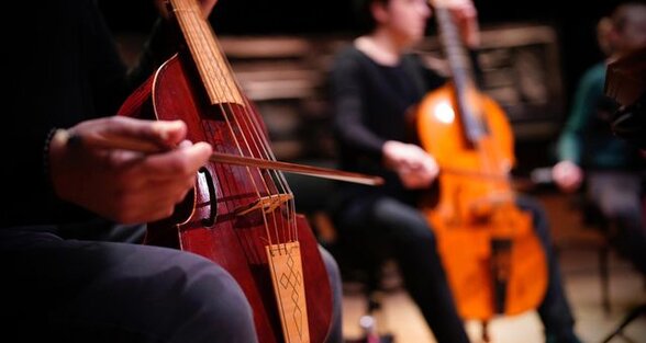 Musiciens en concert jouant de la viole de gambe, gros plan sur l'archet guidant les cordes - Agrandir l'image, fenêtre modale