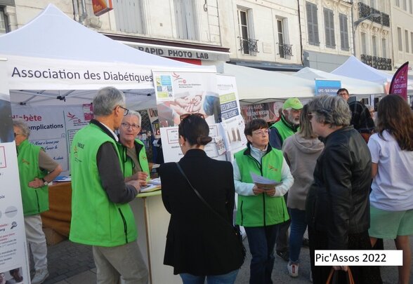Bénévoles en gilet vert échangeant avec des visiteurs au stand extérieur d'information sur le diabète - Agrandir l'image, fenêtre modale