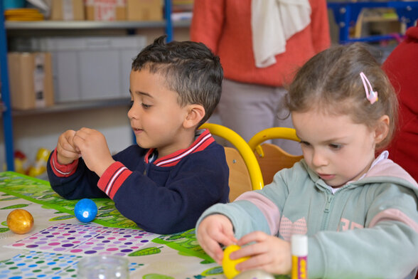 Deux jeunes enfants concentrés sur un bricolage, lors d’un atelier au musée