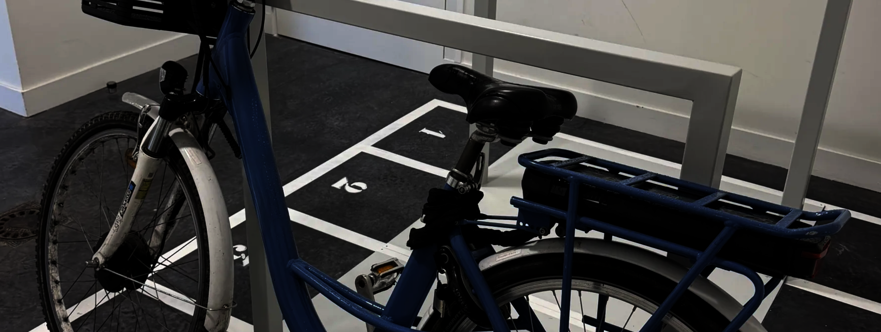Vélo à assistance électrique stationné sur un emplacement numéroté dans le local de stationnement sécurisé