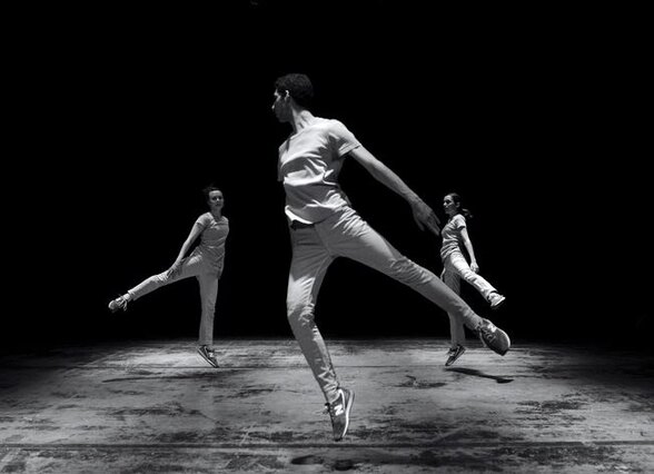 Trois danseurs en plein mouvement sur scène, corps en extension dans une composition chorégraphique contemporaine - Agrandir l'image, fenêtre modale